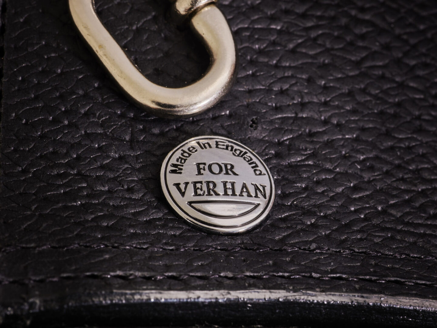 A close up of the back of a purse with a key chain attached.